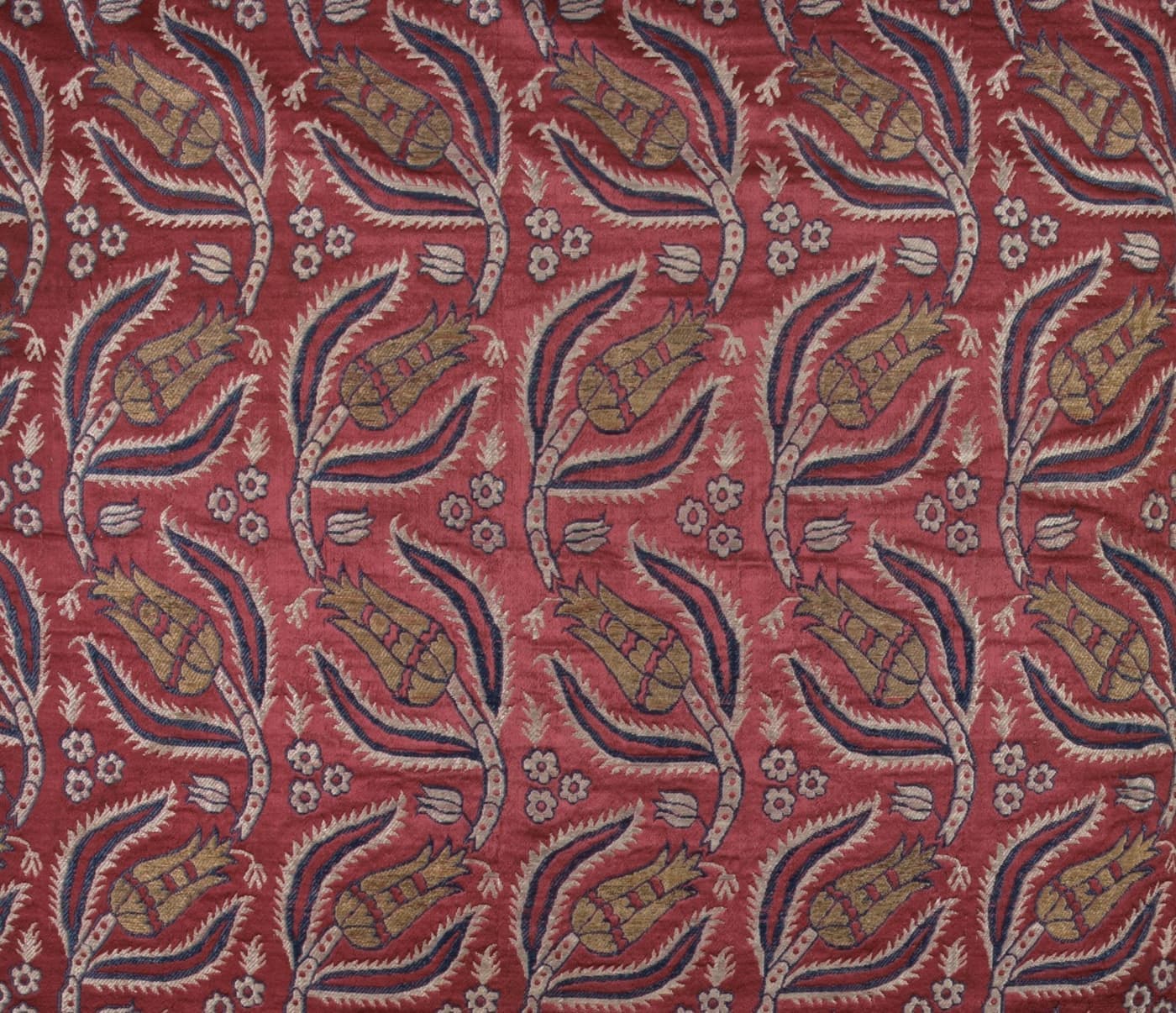 Deep red silk brocade with a trailing pattern of gold and indigo leaf sprays