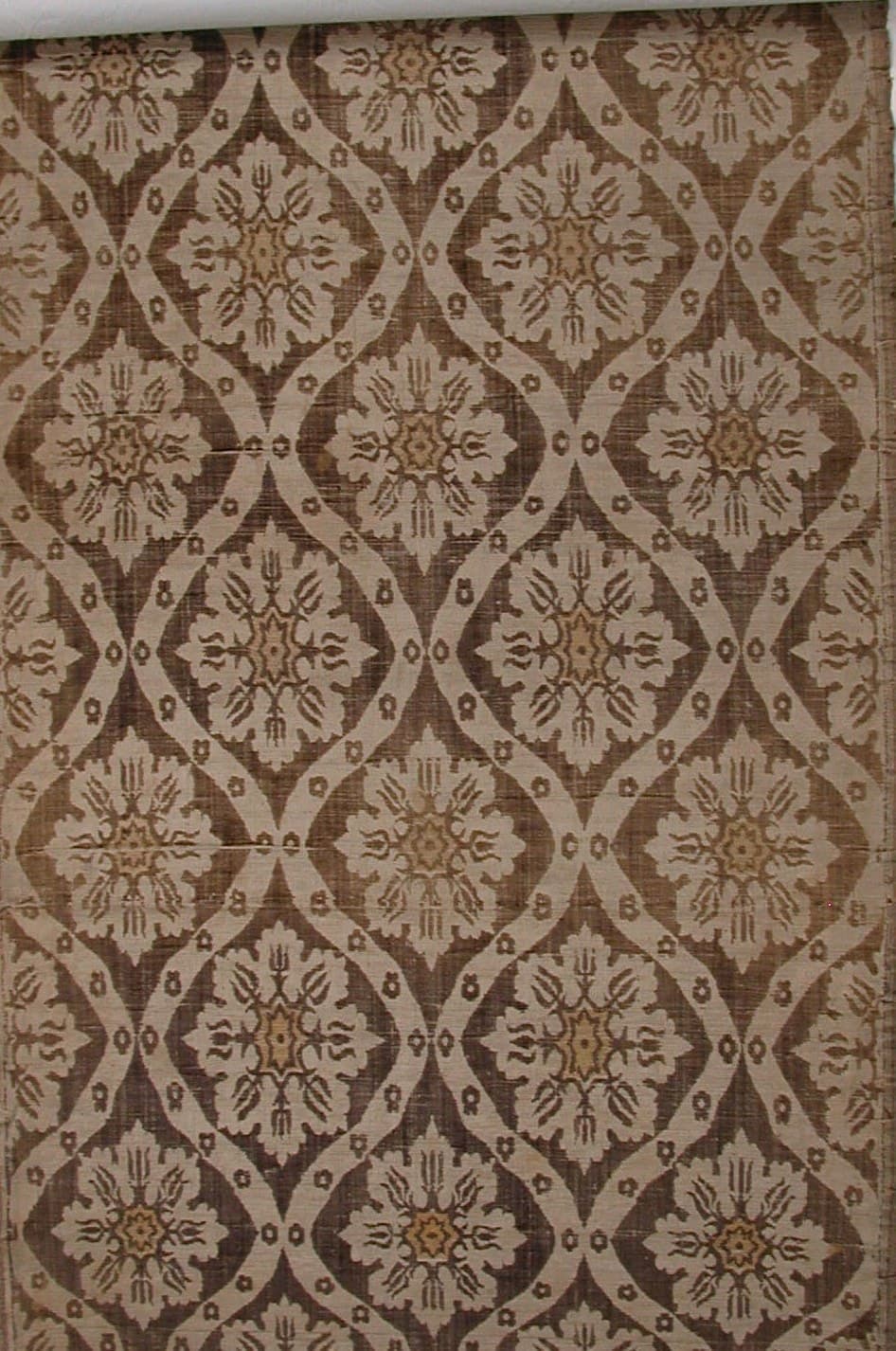 Warm brown and gold silk in an interlocking ogee lattice of stylised blooms
